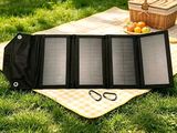a solar panel sitting on a blanket in the grass