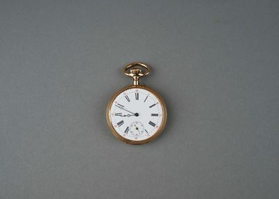 une montre de poche en or avec des chiffres romains sur le cadran