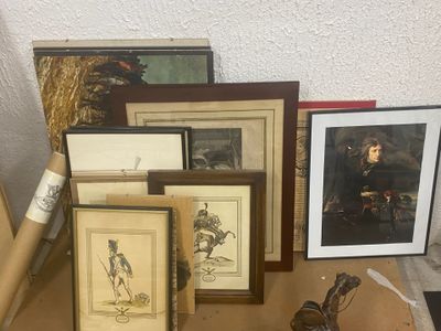 de nombreuses photos encadrées posées sur une table à côté d'une statue représentant un homme