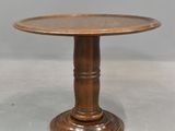 a wooden table with a round top and a wooden base
