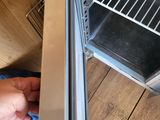 a person opening an open oven door on a wooden floor