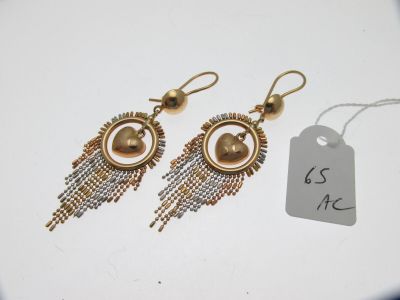 deux paires de boucles d'oreilles accompagnées d'une étiquette, posées sur un fond blanc