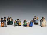 de nombreuses figurines représentant des personnes debout les unes à côté des autres sur une surface blanche