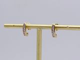 pair of diamond hoop earrings on a gold plated stand