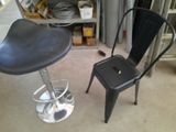 a black chair and a black stool in a garage