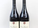deux bouteilles de vin rouge posées l'une à côté de l'autre sur une surface blanche