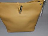 sac à main en cuir beige avec des fermetures éclair sur fond gris