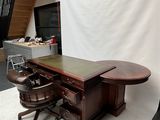 a desk and chair in a room with a white backdrop
