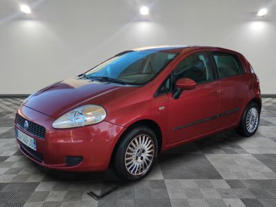 the small red car is parked in the garage on a checkered floor
