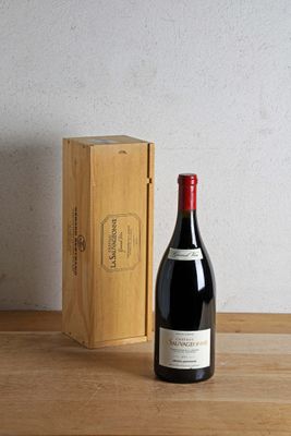 a bottle of wine sitting next to a wooden box on a table