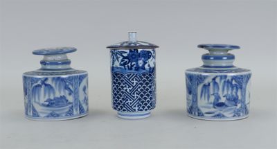 trois vases bleus et blancs avec couvercle, posés sur une surface blanche