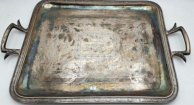un plateau en argent muni de poignées, posé sur une table blanche