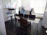 a desk with two laptops and a printer in the room