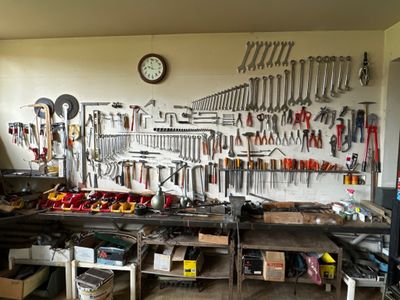 Il y a de nombreux outils accrochés au mur dans ce garage.