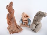 three clay sculptures of people sitting on a chair