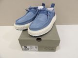 blue sued shoes with white soles on top of a box