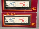 deux boîtes contenant des wagons de train miniature, empilées l'une sur l'autre