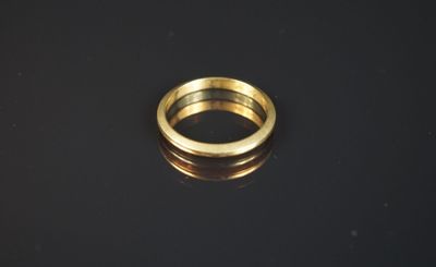 gros plan d'une bague en or sur une surface noire
