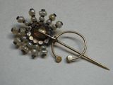 une broche ornée de perles et d'une épingle