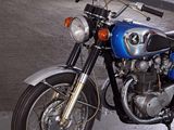 a blue motorcycle parked in a garage with a white wall