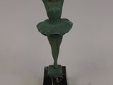 statue of a ballerina in a green tutu on a marble base