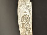 an old silver knife with a picture of a man and a woman on it