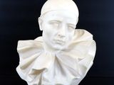 un buste blanc représentant une femme coiffée d'un chapeau