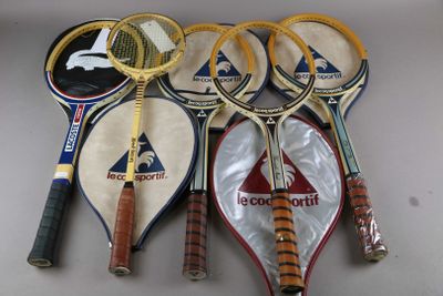 Plusieurs raquettes de tennis sont alignées sur une table