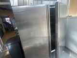 a refrigerator and a trash can inside of a building