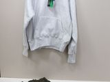 a white hoodie hanging on a wall next to a pair of pants