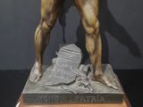 bronze statue of a man holding a bow and arrow on a wooden base