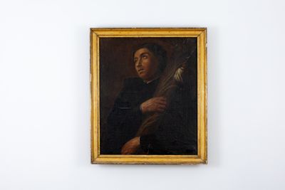 portrait d'un homme tenant une guitare, à côté d'un tableau accroché au mur