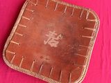 a brown leather tray on a pink table cloth