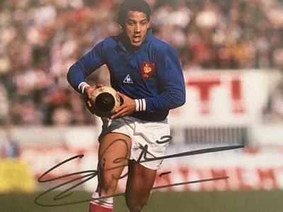 an image of a man running with a soccer ball in his hand