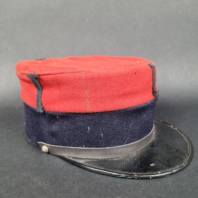 une image représentant un chapeau rouge et bleu posé sur une surface noire