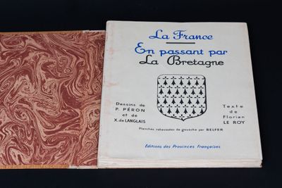 un vieux livre à la couverture rouge posé sur une table noire