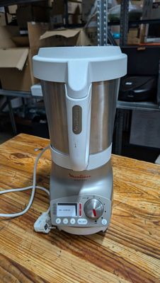 a silver blender sitting on a wooden table