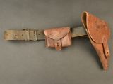 un gros plan sur une ceinture en cuir dans laquelle est glissé un couteau