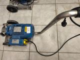 une machine bleue posée par terre à côté d'une autre machine bleue