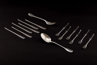 a group of forks and spoons on a black surface