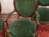 three green velveted chairs sitting on top of a rug on top of a wooden floor