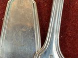 two spoons that are sitting on a red surface