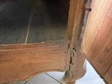 a wooden cabinet with a door open on a tile floor