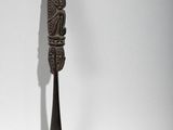 a spoon with a carving on it sitting on a table
