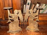 two angel figurines sitting on a table in front of a window