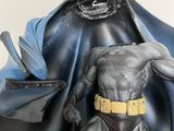 statue of a batman with a cape on his head and a cape on his chest