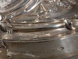 a silver plate with a clock on it on a table
