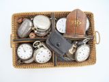 a wicker basket filled with assorted pocket watches