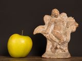 a figurine of an angel and an apple on a table