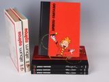 three books are stacked on top of each other on a white surface